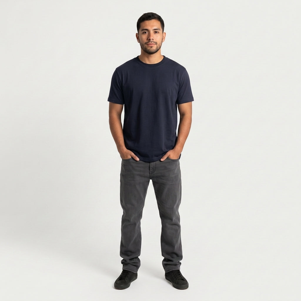 Hombre de frente con la polera azul marino Sólido Studio y jeans grises (color azul marino)