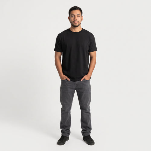 Hombre de frente con la polera negra Sólido Studio y jeans grises (color negro, pack de 3)